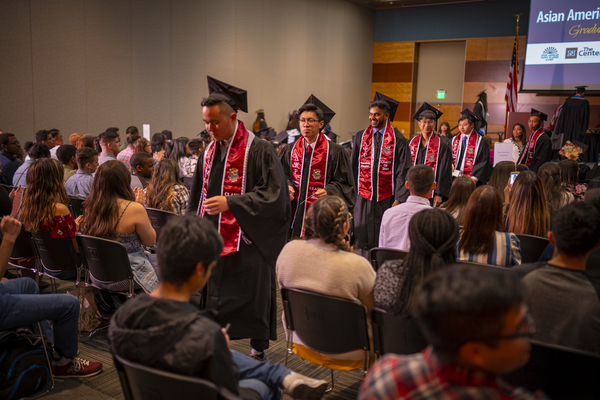 A line of graduates approaching the stage at the Asian American & Pacific Islander Graduate Celebration