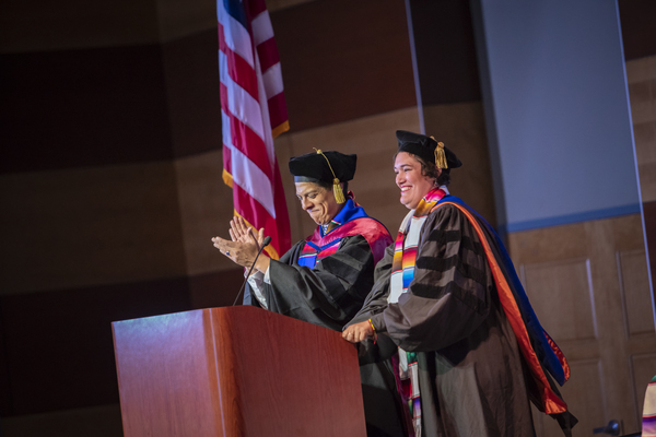 Graduates holding up their caps outside the Latinx Graduate Celebration