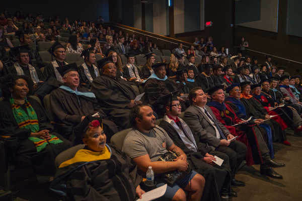 Graduates and faculty members laugh together at the Lavender Graduate Celebration