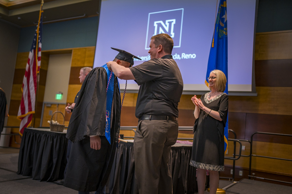 Graduates and faculty members laugh together at the Lavender Graduate Celebration