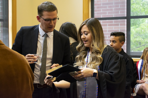 A faculty member and a student chat indoors.