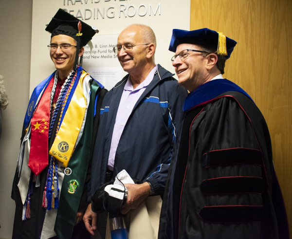 A student, the dean and a parent pose for a picture.