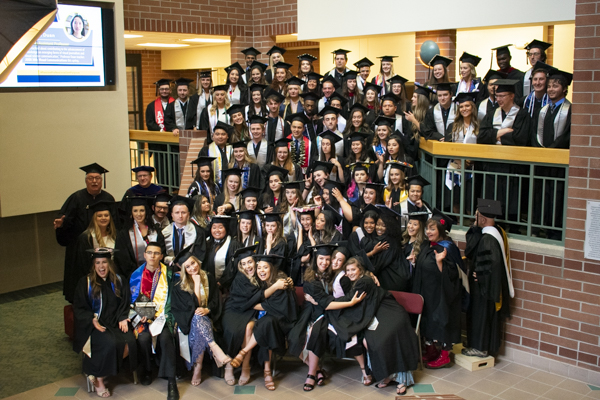 The group of students and faculty do a funny pose in the atrium.