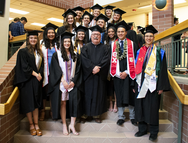 Students and a faculty member pose on the atrium steps.