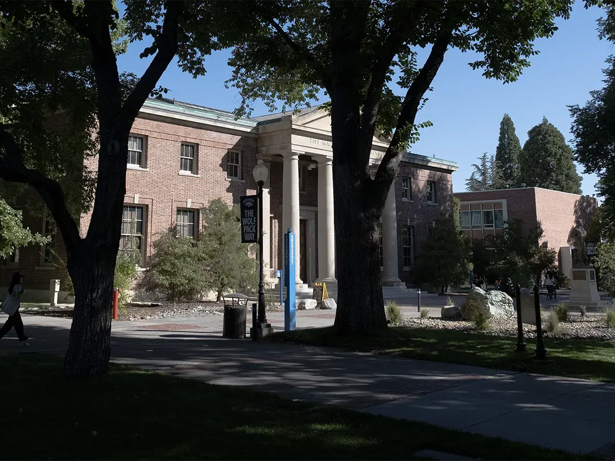 The John Mackay Statute in front of the Mackay School of Mines building surrounded by elm trees on the University of Nevada, Reno Quad.