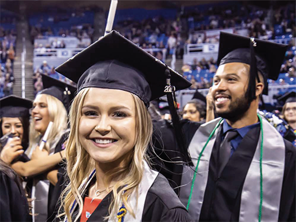 Smiling students at Commencement wearing caps and gowns