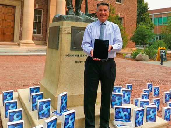 President Brian Sandoval holds an Apple iPad with other iPad boxes sitting on the ground near his feet outside the Mackay School of Mines.