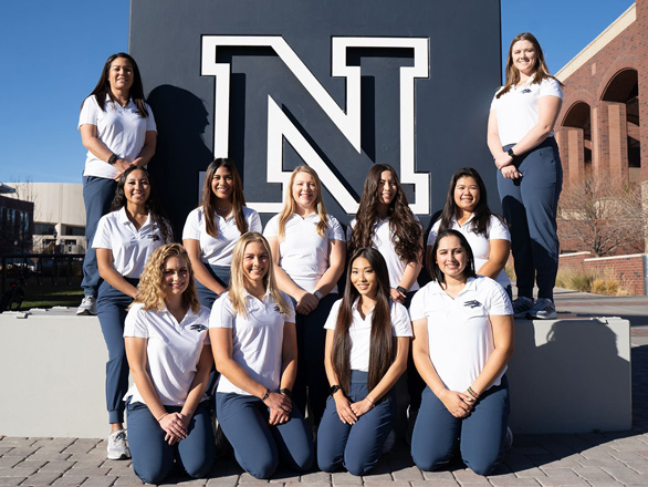 The 2021-22 Nevada women's golf team poses for a picture in front of the University's block N statue.