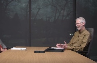 Steve Justice seated at a conference table during an interview or discussion.