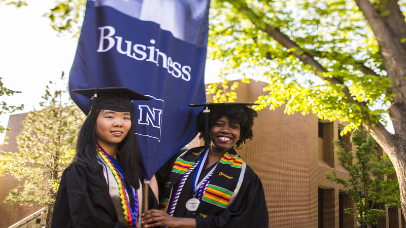 2018 graduates carrying the Business flag before walking