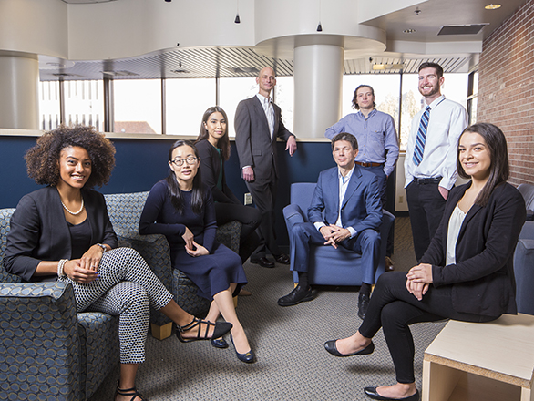 A combination of eight students and faculty from the Marketing unit smiling wearing professional attire.