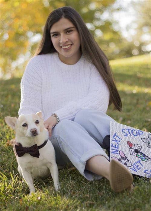 Natalie Godinez with bow-tie wearing dog and "Next stop vet school" decorated cap