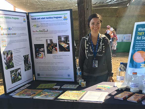 Ana Nunez Zepeda staffs a nutrition education booth for kids and parents at the College's Field Day event.