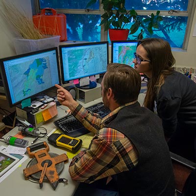 Two people looking at computer monitor.