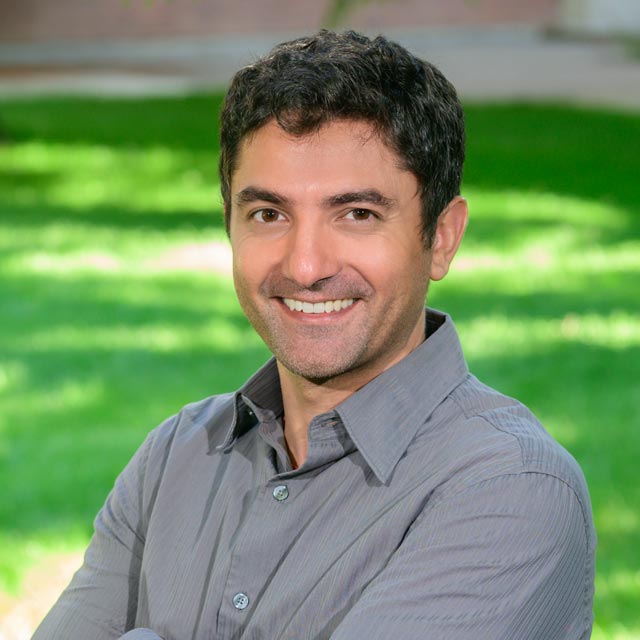 A headshot of a smiling man.