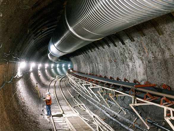 A man working with surveying equipment in the Underground Exploratory Studies Facilities at Yucca Mountain.