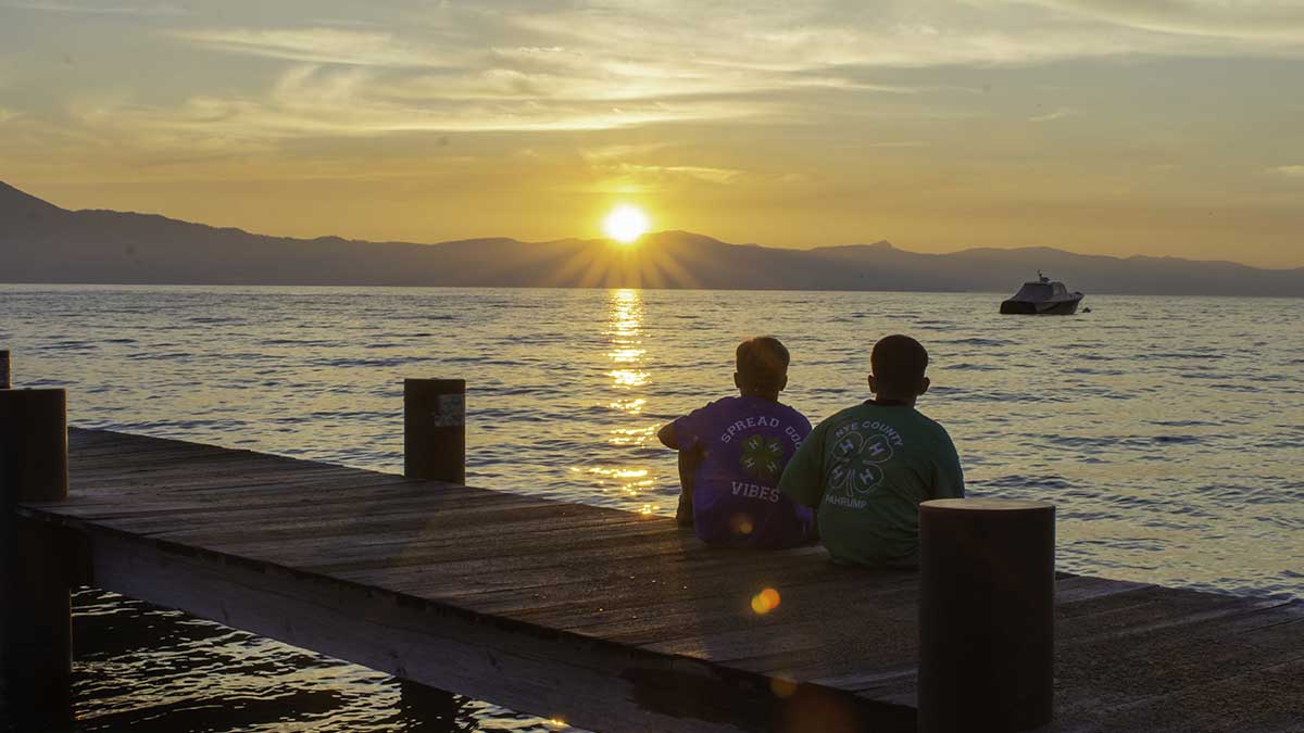 4-H'ers sitting on the dock at 4-H Camp in Lake Tahoe, enjoying the sunset.