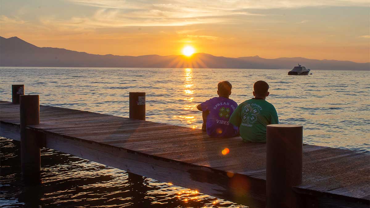 4-H youth sitting on the dock watching the sun set over Lake Tahoe at Nevada 4-H Camp