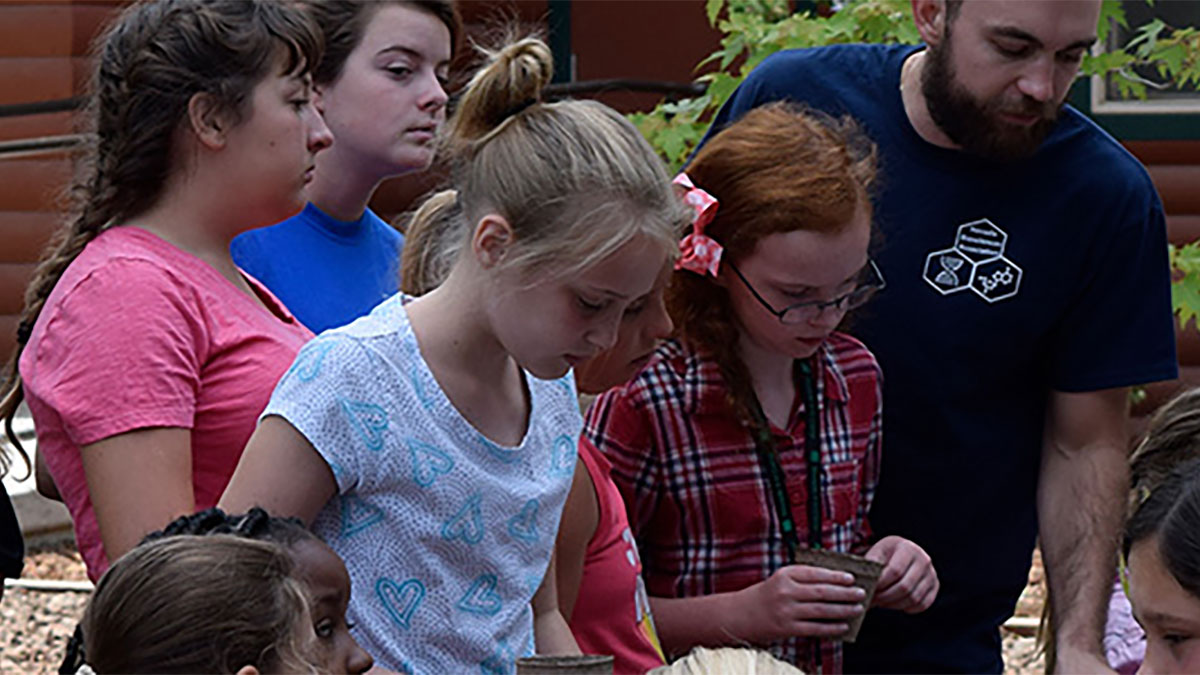 4-H campers doing an experiment on seedlings with graduate student