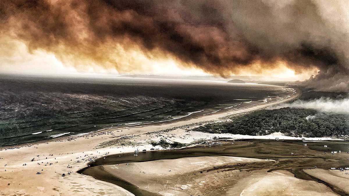 Fire raging and smoke billowing along a populated Australia coastline