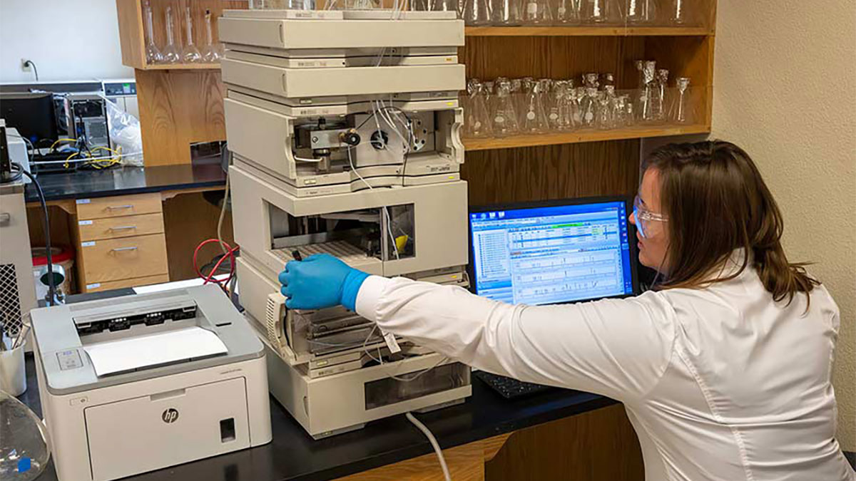 Lab assistant adding samples to a machine.