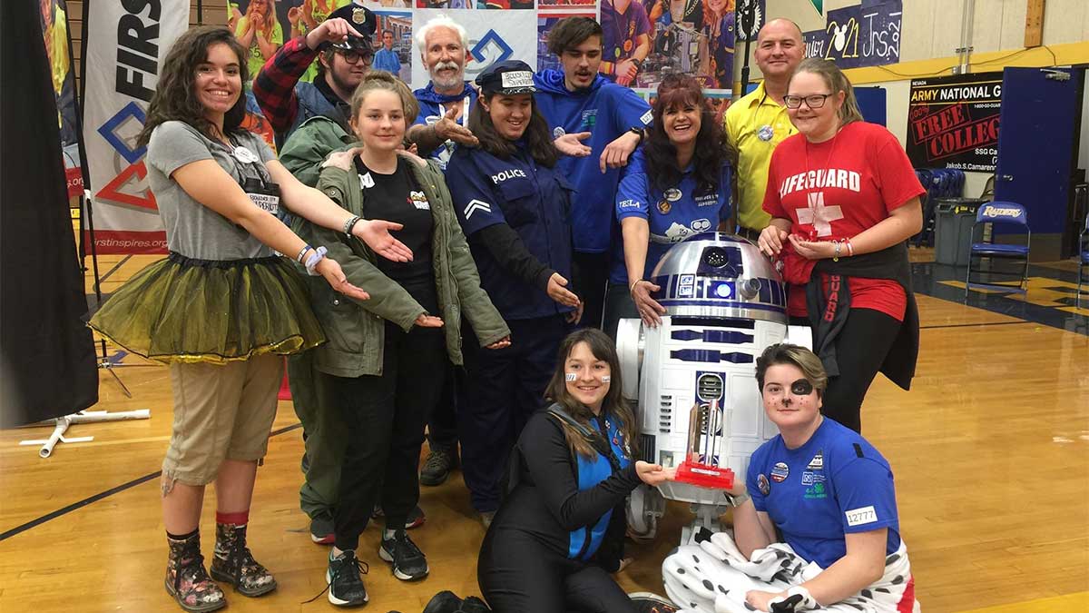 SuperBots and Awkward Silence team members, wearing various Halloween-like costumes, pose with R2D2 at championships