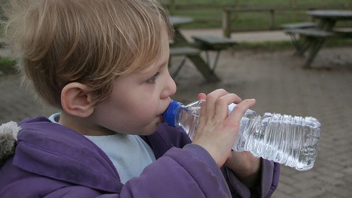 A child drinking from a water bottle