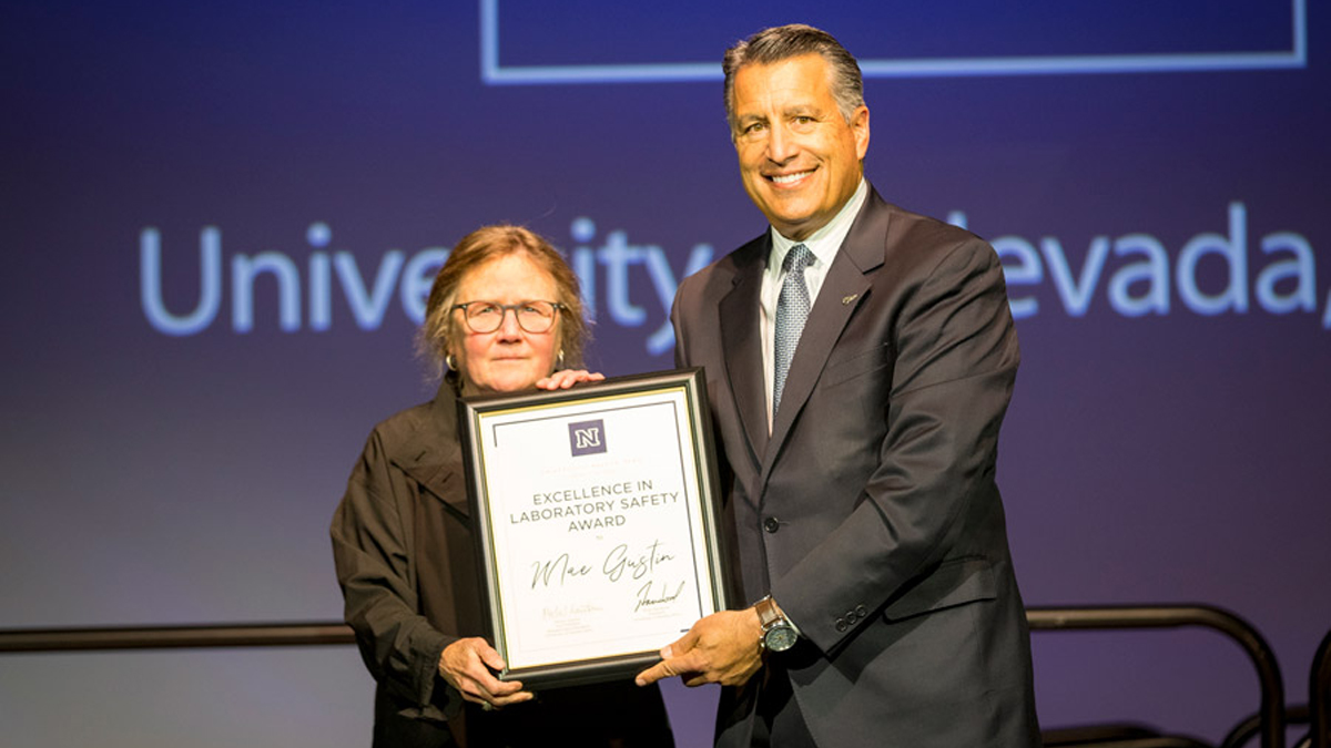 President Sandoval and Mae Gustin holding Excellence in Laboratory Safety Award plaque.