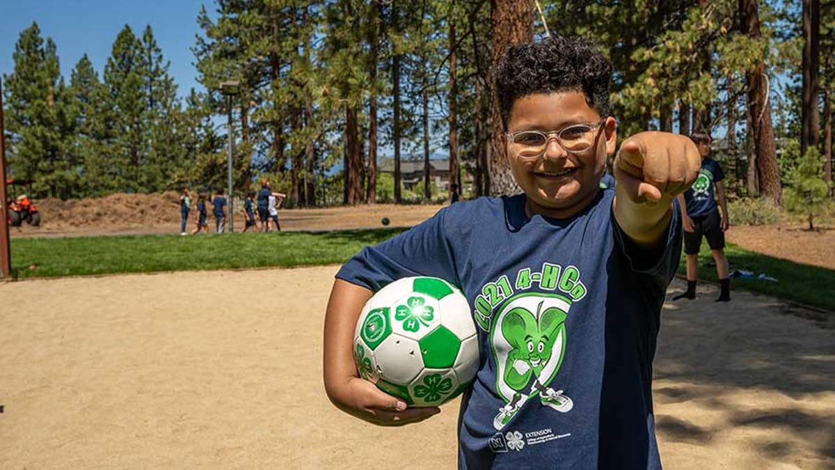 Child playing soccer at 4-H event.