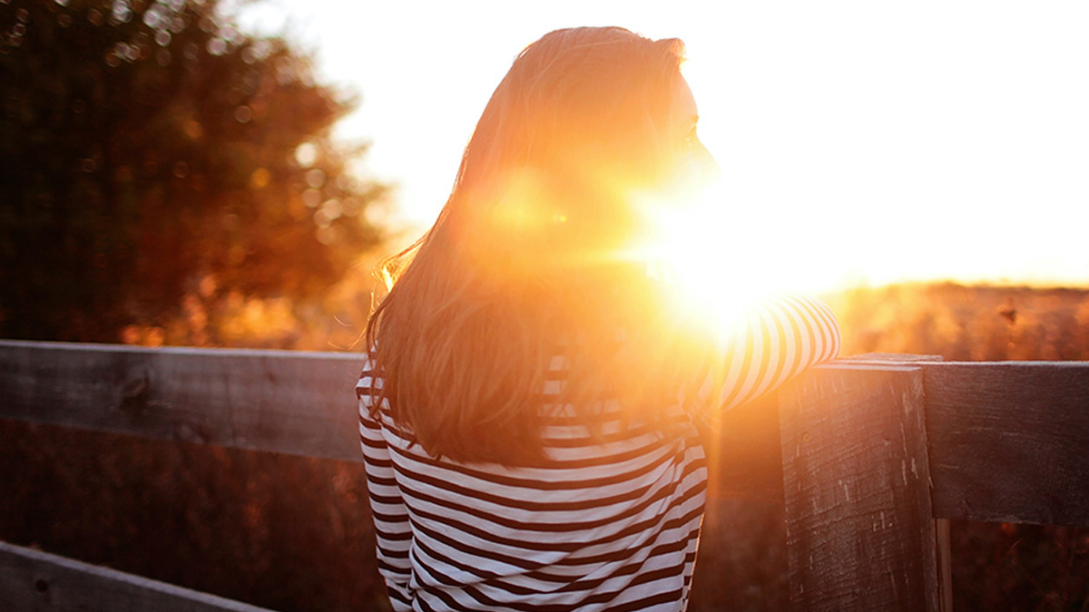 Woman with sunbeams in her face.