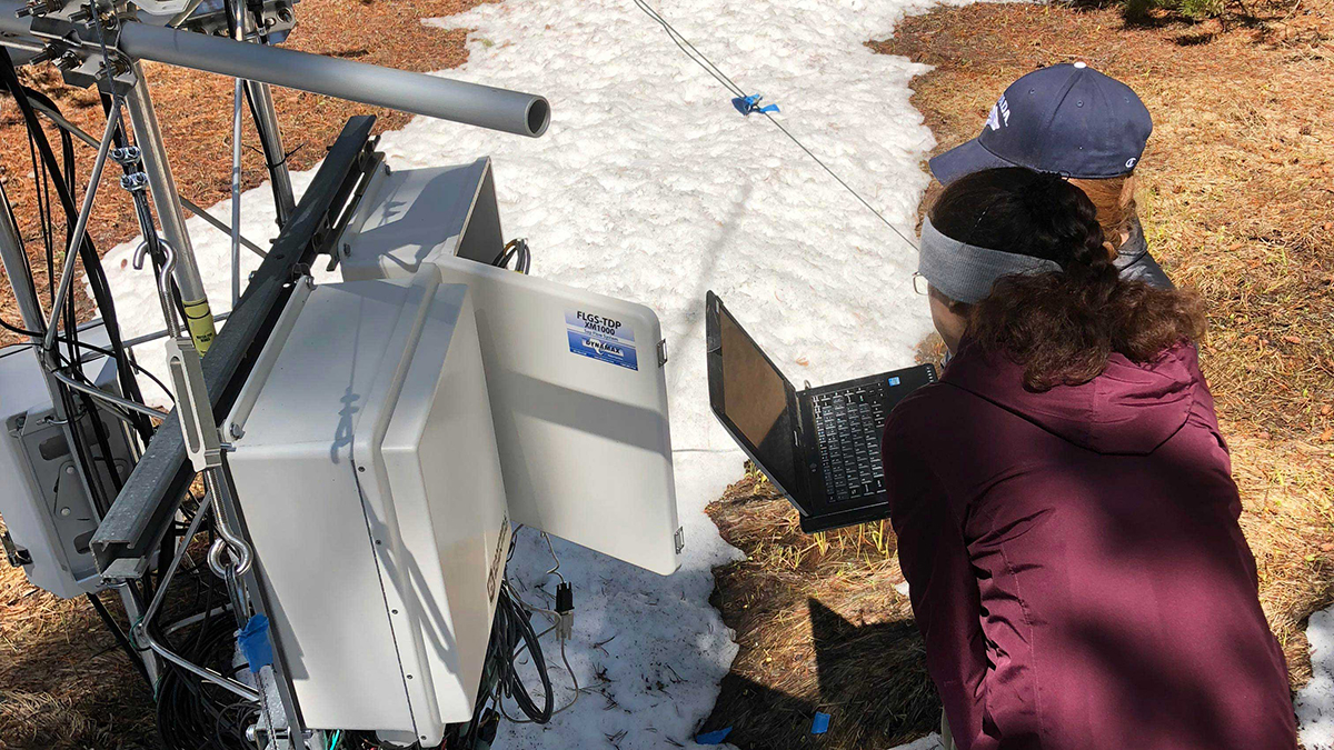 Two women testing data collection equipment in the forest