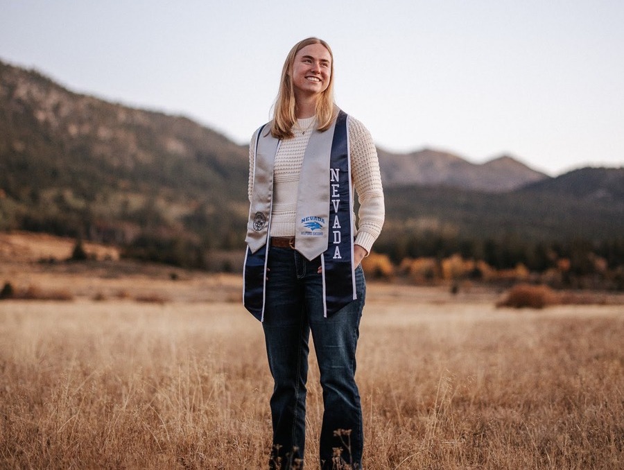 Elsie Childress stands in a field in Nevada regalia.