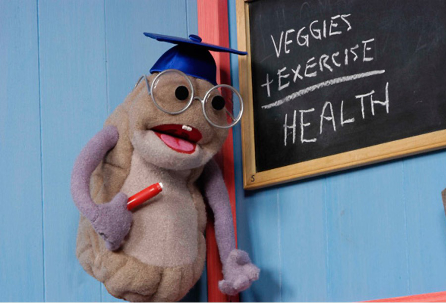 A mascot standing in front of a chalkboard.