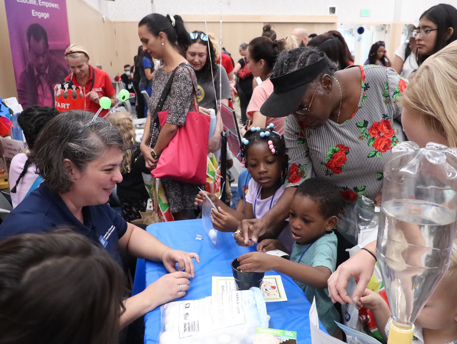 Children and parents participating in a seed growing activity.