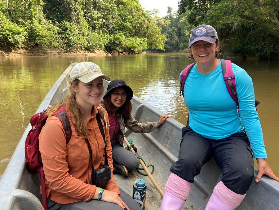 Group of three on a boat on a river.