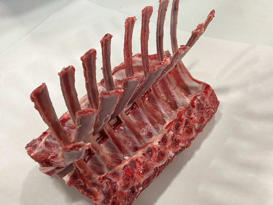 A Wolf Pack Meats rack of lamb on a table.