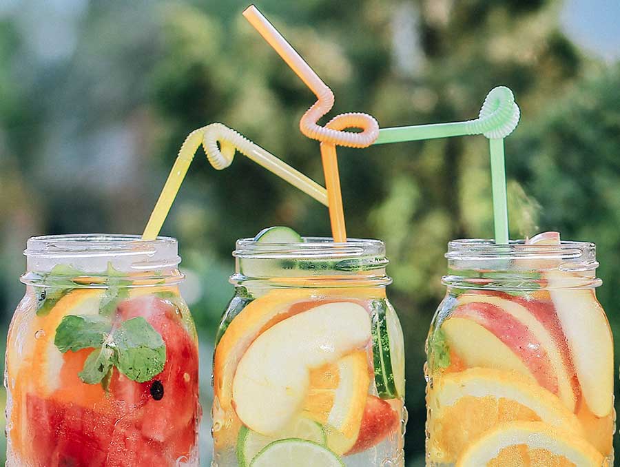 Three sugary fruity drinks in canning jars, each with a colorful bendy straw