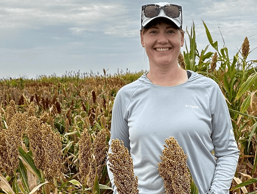 Associate Professor Melinda Yerka outside next to one of her sorghum varieties.