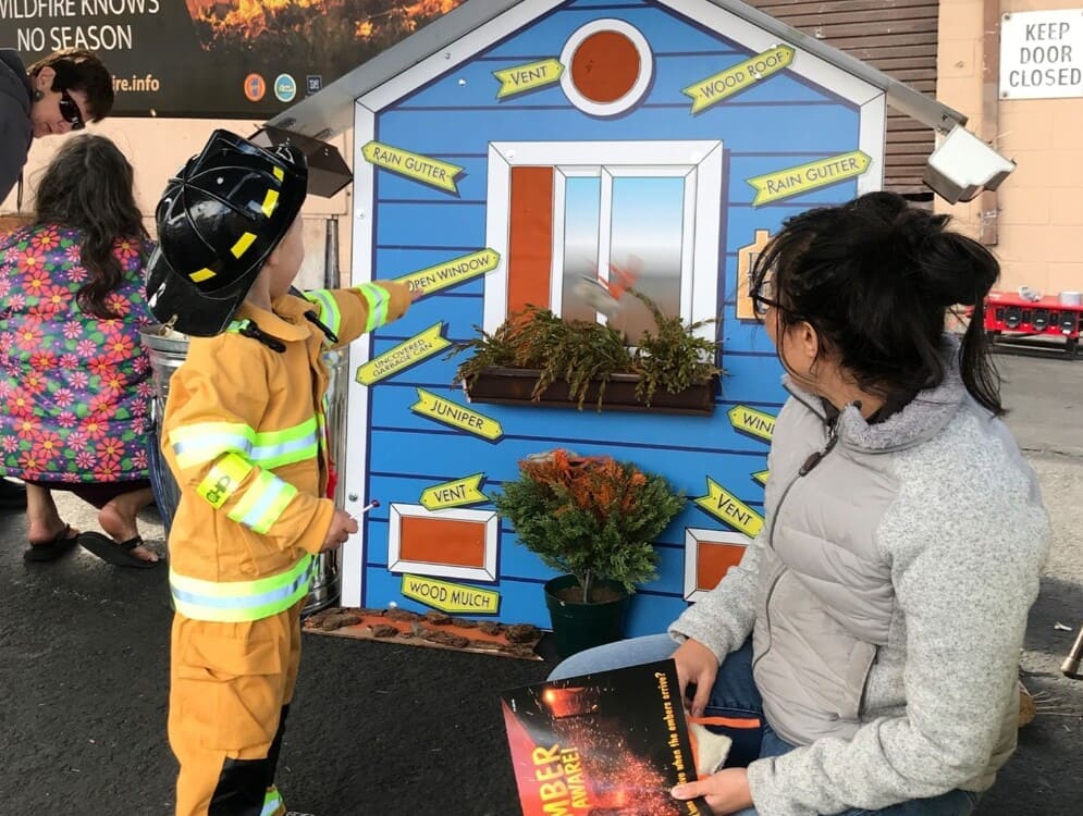 A family with young children learns from an Extension expert how to protect their home from wildfire.