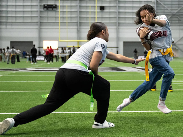 Two youth playing flag football.