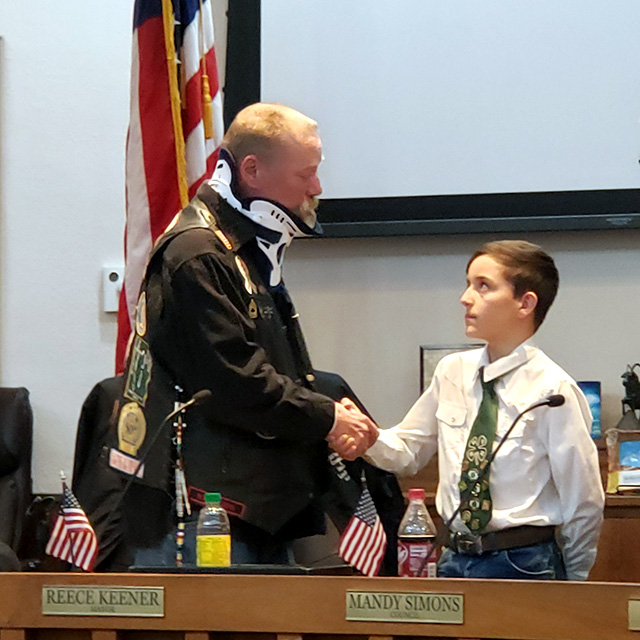 A 4-H youth shaking Lee Foster's hand