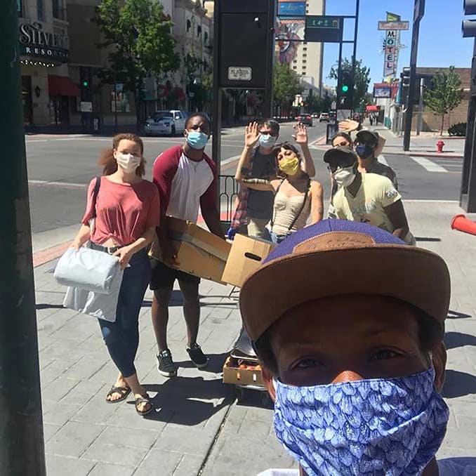 Blaize and his team wearing masks for COVID safety while handing out burritos downtown 