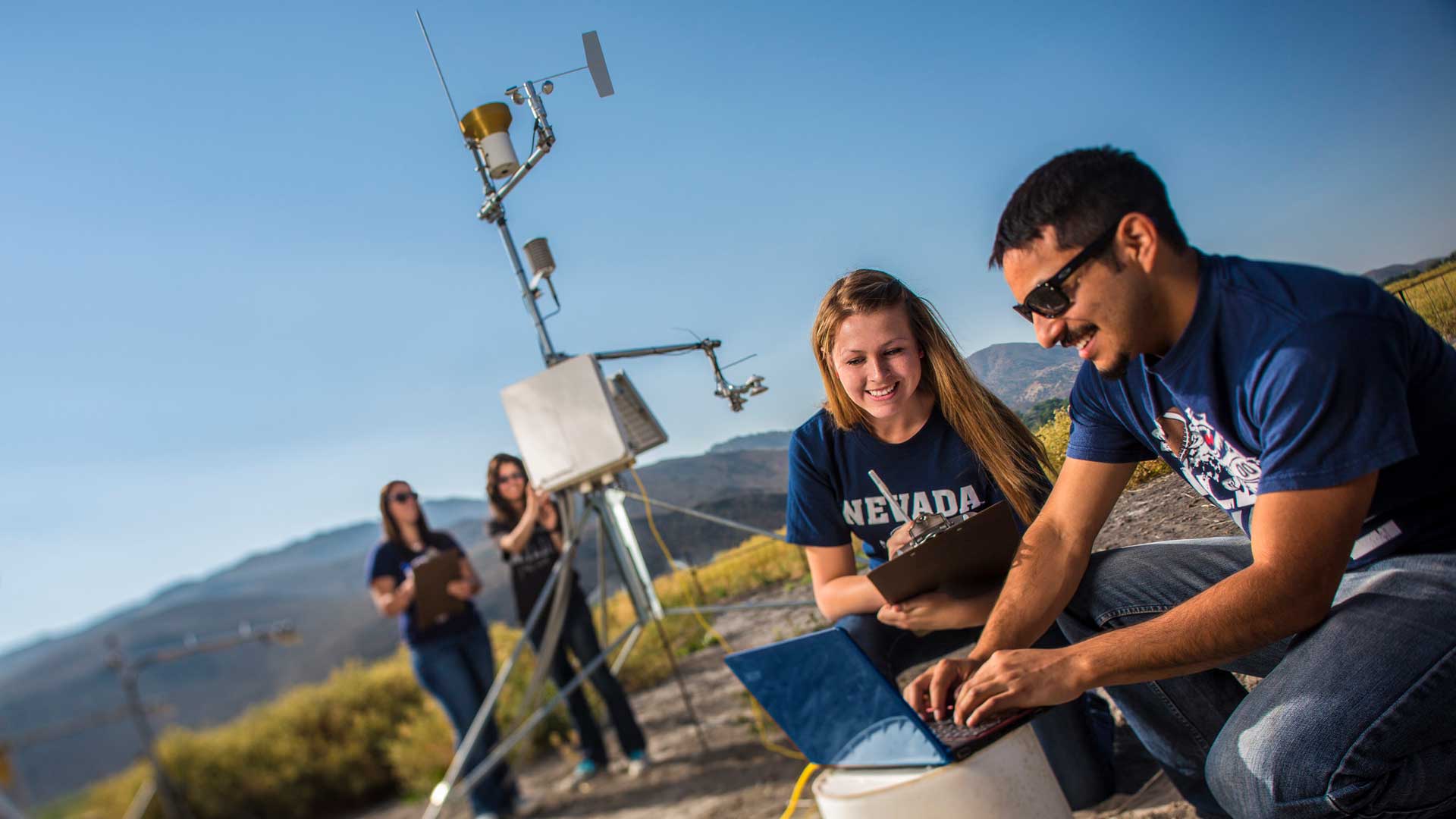 Researchers working outdoors with scientific equipment.
