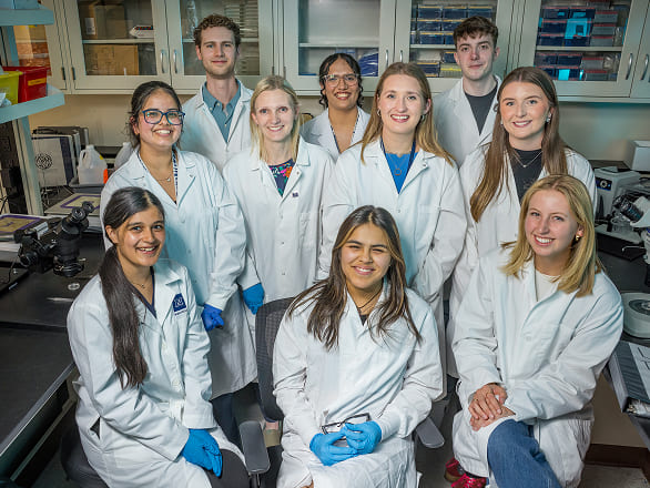 A group of researchers stand together in the lab for a group shot