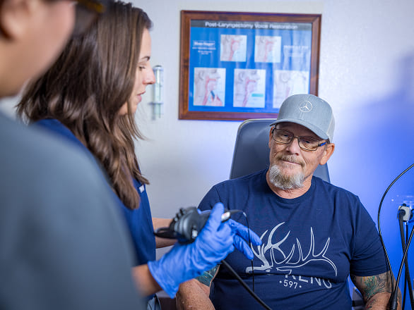 An older Nevadan sits in a clinic ready to be tested by medical staff in the room