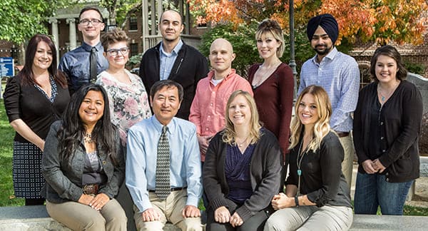 Twelve staff members of CSES smile for a photo outside.