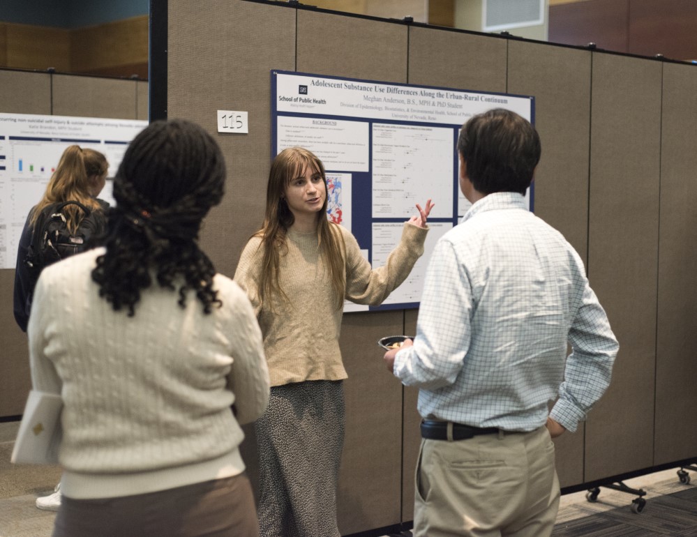 Student presenting at Delta Phi poster event