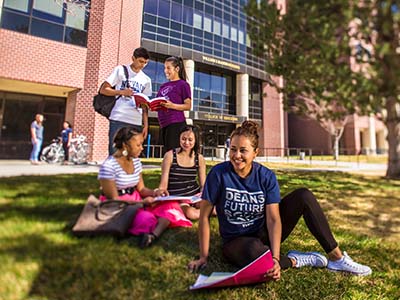 Students sitting and standing outside of the Raggio Building