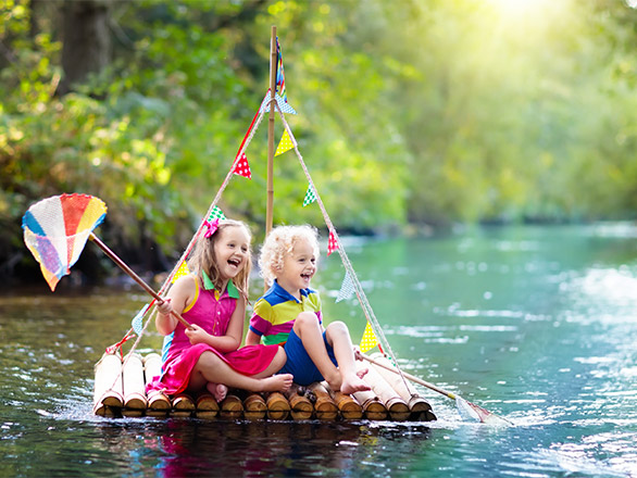 Kids on a boat in the river smiling