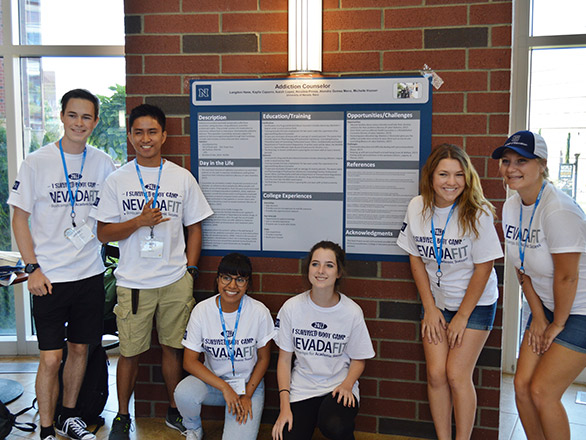 Students posing in front of poster